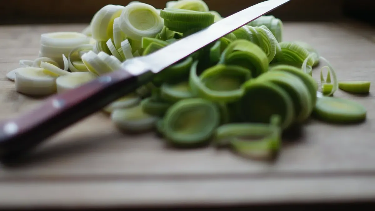 Sliced yellow onion on a wooden cutting board with a dog resting in the background